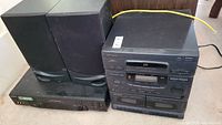 Optimus stacked stereo system main unit with two speakers and additional Sony VHS player unit