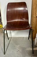 Front view of moulded rosewood chair with green steel legs
