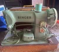 Left side view of Singer 185J sewing machine showing turquoise body and attached cords