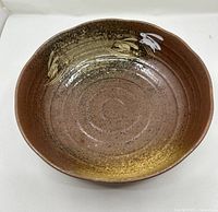 Top view of brown ceramic bowl with gold interior accents and rabbit design