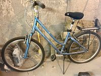 Full side view of blue Giant Sedona bicycle leaning against wall