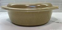 Side view of tan speckled casserole with lid