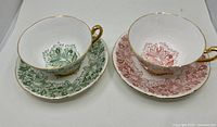 Front view of both teacup and saucer sets showing green and red patterns