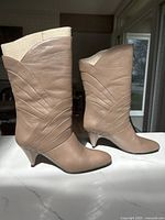 Both boots standing upright showing leather color, stitched design and heel style
