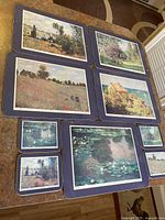 Set of 5 cork coasters and place mats laid out showing various Claude Monet painting reproductions.