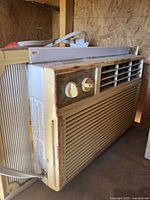 Front view of the Forest Air window AC unit with control knobs and adjustable side panel.