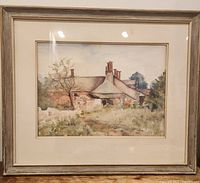 Framed watercolour painting showing the entire view of the country cottage, frame, and matting.
