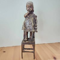 Frontal view of full sculpture showing girl atop chair
