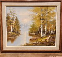 Frontal view of the framed landscape oil painting featuring a river and trees in autumn colors.