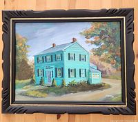 Full front view of the framed vintage oil painting of a blue-green house with autumn trees in background.