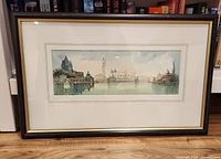 Frontal view of the framed watercolour painting showing Venice skyline with domes and bell towers, matted and framed in black with gold inner trim.