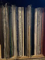 Side view of the collection of vinyl records showing spines with composer and title information on album covers.