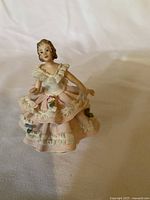 Front view of the porcelain lace figurine showing the detailed dress and floral decorations