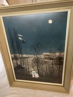 Front view of the framed print showing the artwork with a night scene and two figures walking under the moonlight.