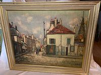 Front view of framed textured print artwork titled 'Small Hostelry' by Maurice Utrillo featuring a street scene with buildings and figures.