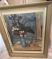 Full view of the framed vintage print showing the blue vase with flowers and part of the frame's wood finish.