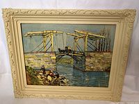 Front view of the framed print showing the Langlois Bridge at Arles painting by Vincent Van Gogh in a beige carved plastic frame.