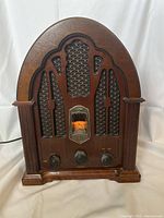 Front view of vintage GE AM/FM radio with wooden arch cabinet and control knobs