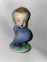 Front and side view of the Wade figurine showing boy in blue pajamas holding teddy bear behind back