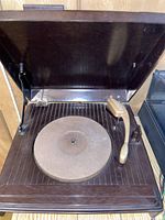 Top view of the open Columbia record player showing the turntable and gold-tone tonearm inside the dark brown plastic case.