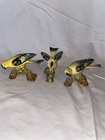 Front view of all three Wade ceramic bird figurines on white cloth background.