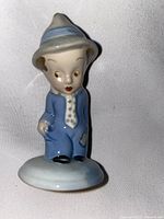 Front and side view of the Wade 'Poor Man' ceramic figurine showing detailed face, blue suit, tie, and hat.