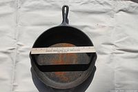 Top view of the 12 inch Lodge 109K cast iron pan with a ruler showing size, some rust visible inside.