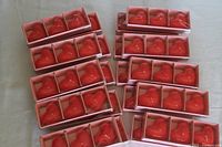 Boxes of red heart-shaped floating candles arranged on a surface, showing multiple new boxed sets.