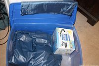 Blue Rubbermaid storage box containing folded navy blue twin inflatable mattress and boxed electric pump inside.