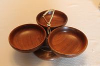 Three wooden snack bowls mounted on a Lazy Susan base with a central metal handle