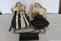 Group photo of all five bags and wallet on a white surface