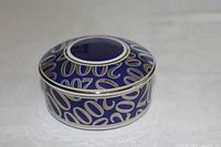 Round blue trinket box with silver and gold '2000' design on the lid and sides, showing top angle view.