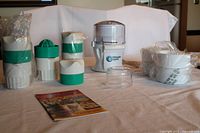 Ultimate Chopper unit with chopping cups, three manual citrus reamers and user manual on table