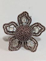 Front view of the silver ring with garnet stones and moonstone cabochons in a flower shape.