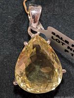 Close-up of lemon quartz gemstone pendant showing faceted pear shape and silver prong setting