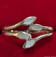 Close-up of the silver mother of pearl ring showing the marquise-shaped insets on a red background.