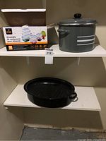 Roasting pan, pot, and boxed food storage containers on shelf