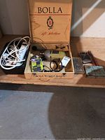 Black & Decker drill in yellow with boxed drill bits, loose drill bits and wooden Bolla gift box on wooden surface