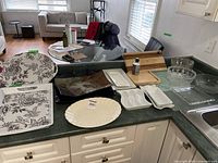 Overview of all items spread on kitchen counter showing trays, platters, cutting boards, and bowls