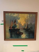 Frontal photo of oil painting in wooden frame showing sailing ships on water with strong yellow and blue colors in the sky and water reflections.