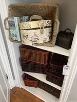 Large woven basket with two decorative boxes inside and two dark woven baskets underneath on a white shelving unit