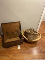 Open wooden chest positioned next to two baskets on the floor, showcasing the overall lot