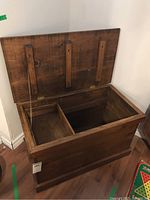 Open wooden trunk showing interior and movable shelf