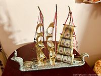 Full view of the clipper ship model showing all three masts and currency sails with rigging on a dark wooden surface