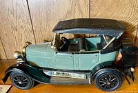 Full side view photo of the Jim Beam bottle in the shape of a green and black 1929 Ford Model A Phaeton car with visible detailing and black convertible roof.