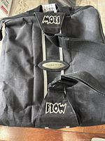 Full view of the black canvas ski boot bag with visible Flow logo and adjustable strap.