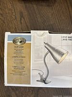 Box showing Hampton Bay Clip Lamp with satin chrome finish and metal shade, product dimensions and SKU details.