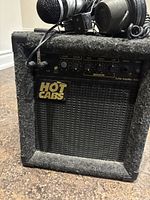 Front and angled view showing black Hot Cabs H108 amplifier with control knobs.