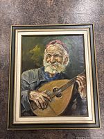 Full view of the oil painting showing elderly man playing lute-like instrument, with wooden frame.