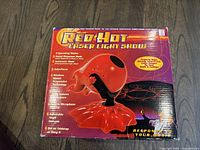 Photo showing the Red Hot Laser Light Show box with product image and features listed on the front.